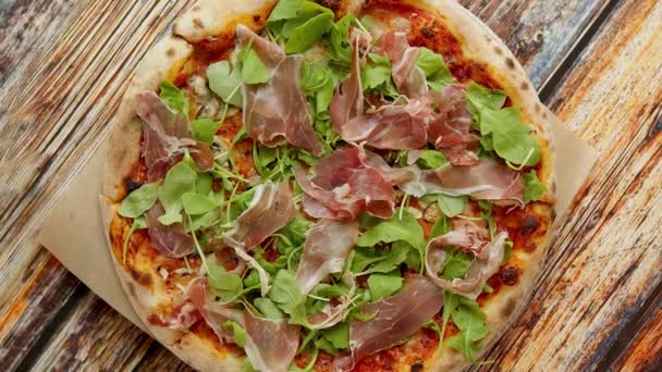 Pyszne domowe włoskie prosciutto i pizza rukola umieszczone na drewnianym tle — Wideo stockowe