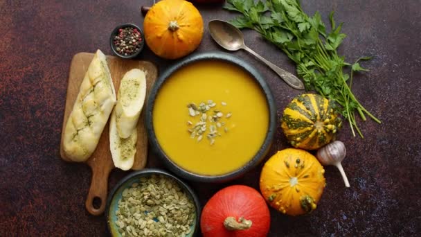 Sopa de creme de abóbora vegetariana caseira servida em tigela de cerâmica. Decorado com sementes — Vídeo de Stock