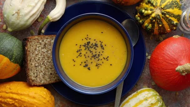 Compositon met herfst klassiek eten. Lekkere zelfgemaakte pompoensoep versierd met zwart zaad — Stockvideo