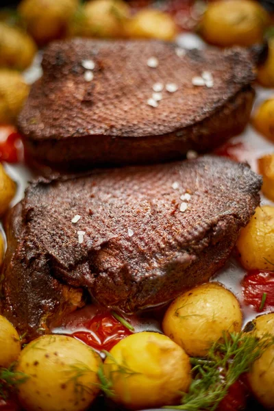 Dekat Bebek Panggang atau dada angsa. Disajikan dengan kentang panggang dan tomat ceri — Stok Foto