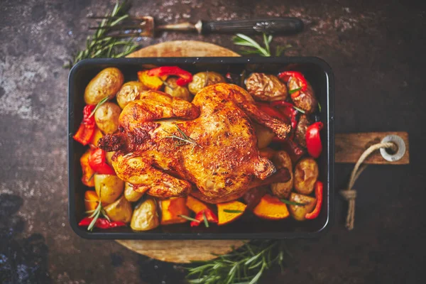 Délicieux poulet entier cuit avec citrouille, poivre et pommes de terre. Servi dans un moule en métal. — Photo