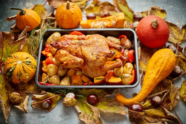 Geroosterde kip of kalkoen gegarneerd met pompoenen, peper en aardappelen. Gediend op een rustieke tafel — Stockfoto