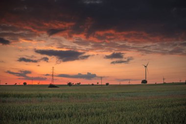 kızıl gökyüzü ve alanlar üzerinde güneş battıktan sonra kara bulutlar