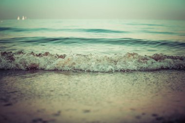 Küçük dalgaların kumlu bir kıyıya vuruşunun yatay görüntüsü