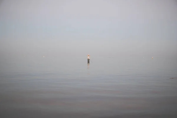 日落时平静海面上的忧郁海景单个浮标 — 图库照片