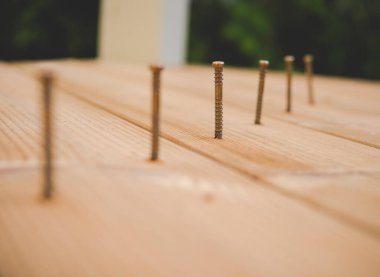 Ahşap terasın yapımı sırasında bir sıra metal vidayı kapatın.