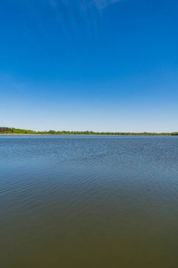Gölün karşı kıyısına bakan manzara uzaklarda görünüyor.