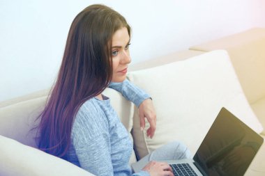 kanepede oturan ve evde laptop ile çalışan kadın 