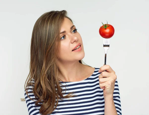 Sorrindo mulher segurando tomate no garfo olhando para cima . — Fotografia de Stock