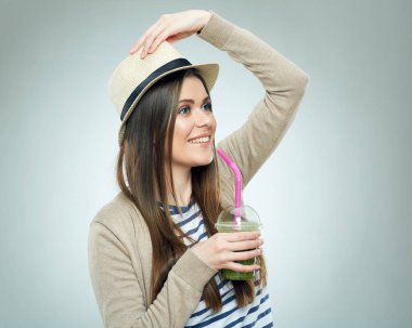 Gülümseyen kadın suyu cam yeşil smoothie ile holding şapkası 