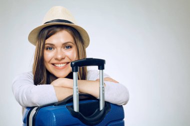 Şapka giyen gülümseyen kadın eller bavula, seyahat kavramı katlanmış.