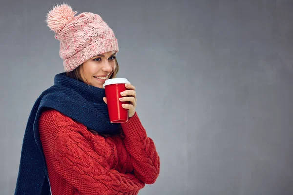 灰色の背景の赤いガラスからホット コーヒーを飲んで冬服の女性 — ストック写真