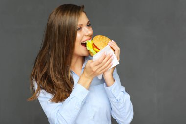 Gülümseyen hamburger yeme ve kağıt mendil kullanarak kadın 