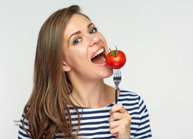 Beyaz arka plan üzerinde izole çatal ile domates yeme kadın portresi,