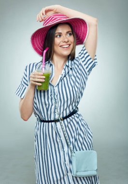 Mutlu kadın cam yeşil suyu ile tutarak yaz şapka