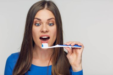 ile gülümseyen ve diş fırçası tutan bir kadın portresi