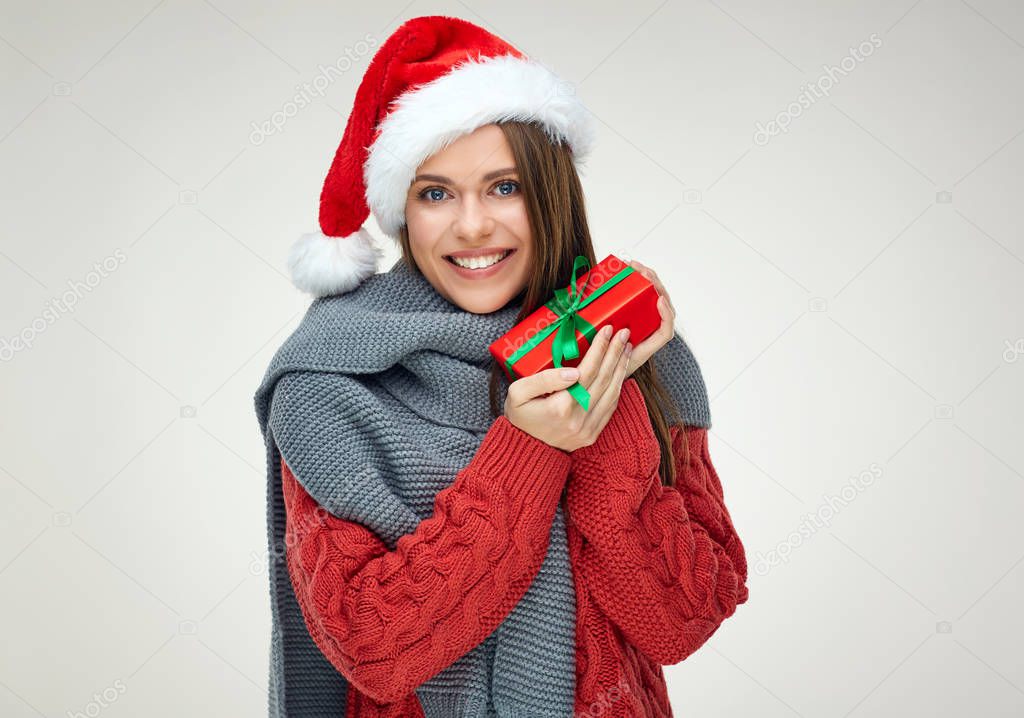 Happy woman in Santa hat celebrating Christmas holiday and holding gift 