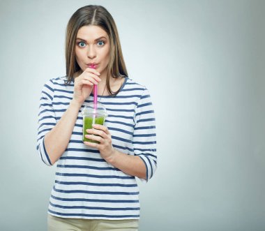Genç kadın güler yüzlü içme. İzole yeşil holding gülümseyen kız portresi Detoks içecek.