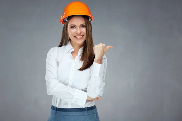 Uśmiechnięta Bizneswoman Kasku Budowniczym Wskazująca Kciukiem Bok Odizolowany Portret Szarej — Zdjęcie stockowe