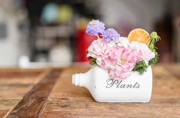Gyönyörű virágok és cserepes pot fehér üveg, fa — Stock Fotó