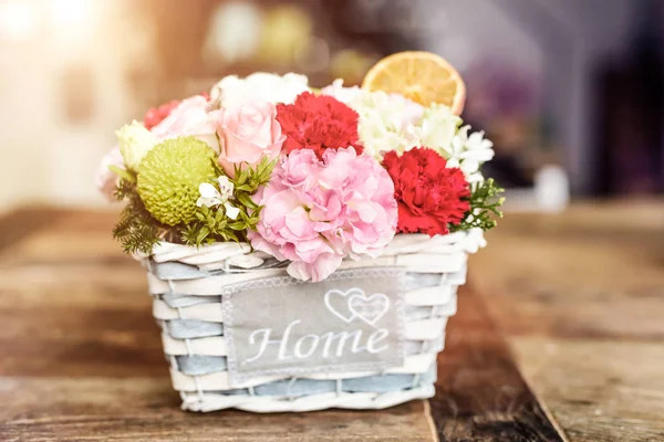 Close-up of beautiful flowers in box with HOME word — Stock Photo, Image