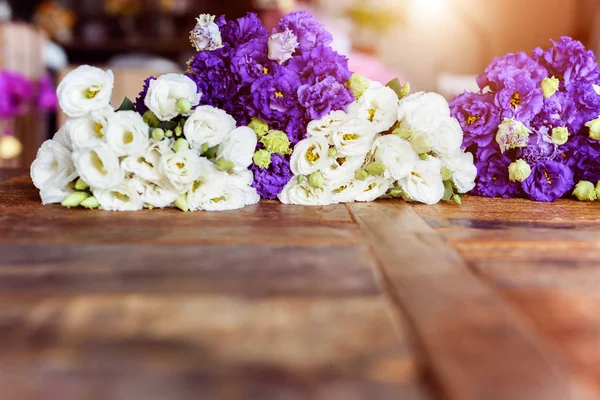 Purple and white flowers on wooden surface Royalty Free Stock Images