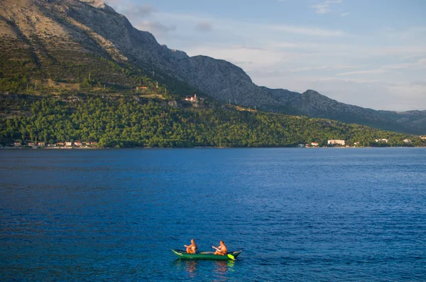 Όμορφη Μπλε Θάλασσα Κωπηλάτες Και Ένα Βουνό Στο Παρασκήνιο — Φωτογραφία Αρχείου