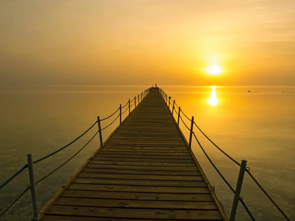 Pier in de stralen van de rijzende zon. Morgen op de rode zee — Stockfoto