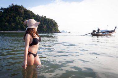 Uzak denizde seyir güzel kız Tayland bir plajda.
