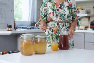 Genç kadın onun kombucha mutfakta çay hazırlama.