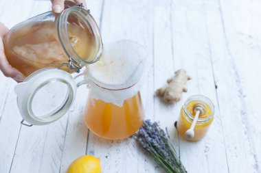 Genç kadın fermente yeşil çay çaydanlık dökme.