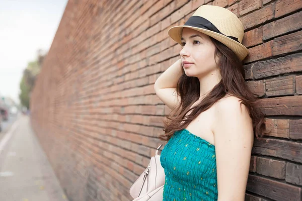 Bir tuğla duvara yaslanmış güzel bayanı.