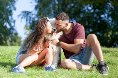 Onların köpek ile kaliteli zaman parkta sahip güzel genç çift.