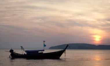Bir izole long tail tekne ile gün batımı görünümü.