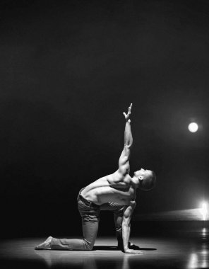 genç ve kaslı bir adam bir sahnede bir çağdaş dans poz gerçekleştirme.