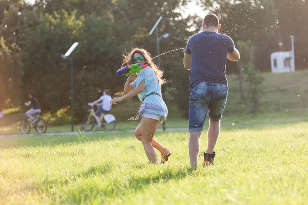 Playful Young Couple Chasing Each Other Playing Water Guns Meadow — Stock Photo, Image