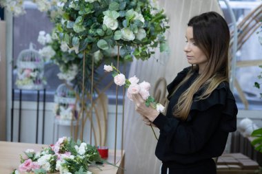 Çiçek süsleme atölyesi üzerinde çalışan genç kadın girişimci.