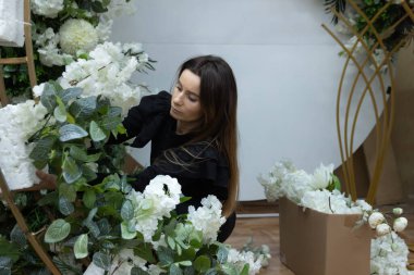 Çiçek süsleme atölyesi üzerinde çalışan genç kadın girişimci.