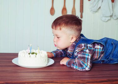 bebek evde mum ile büyük bir pasta ile mutfakta