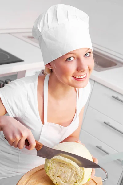 漂亮的年轻女子在厨房里切白菜 — 图库照片