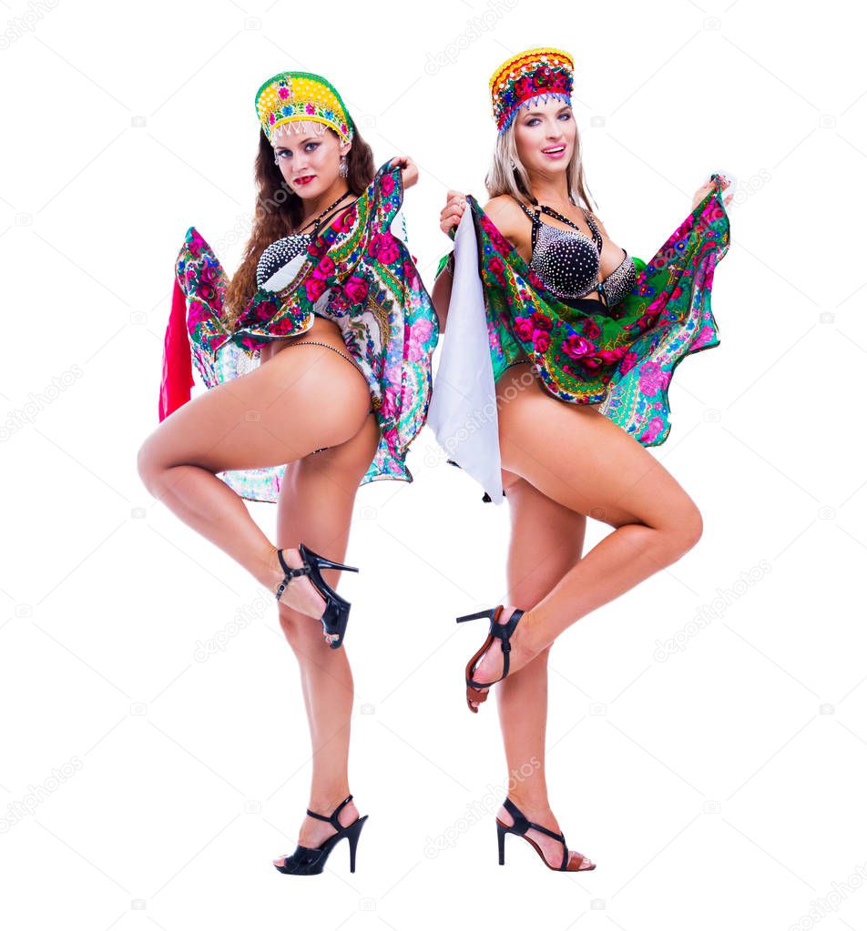 two beautiful women striptease dancers performing russian traditional folk dance, isolated against white