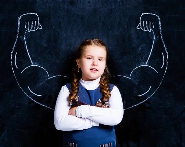 Schattige Kleine Schoolmeisje Tegen Schoolbord Met Getekende Sterke Gespierde Armen — Stockfoto