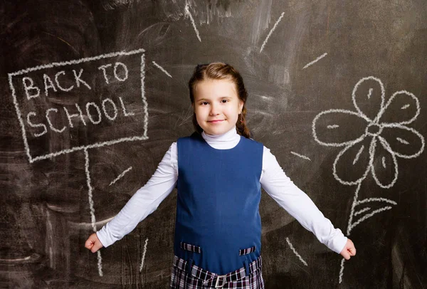 Nettes Kleines Schulmädchen Gegen Kreidetafel Mit Gezeichneter Blume Und Teller — Stockfoto