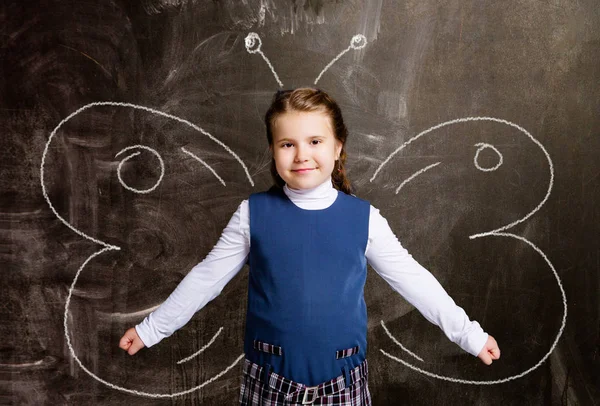 黒板に描かれた蝶の羽に対してかわいい小さな女子高生 — ストック写真