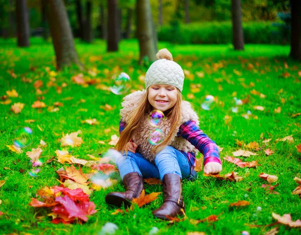快乐的小女孩花时间和玩肥皂气泡户外在秋季公园 — 图库照片