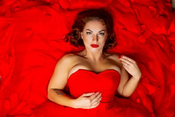 赤いドレスを着てバラのタトゥーを持つ美しい若い女性 — ストック写真