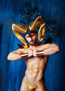 stüdyoda büyük altın boynuzlarıyla sahne kostüm giyen kaslı yakışıklı adam