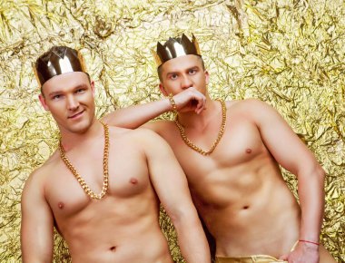 Studio altın studio arka plan karşı altın kron ile kostümleri giyen iki striptiz dansçı