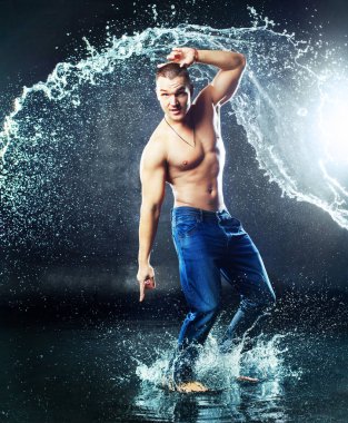 yağmur ve splash su, stüdyo photoshoot altında ıslak giysileri ile çekici bir genç adam
