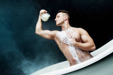 çekici kas genç adam süt ile banyo